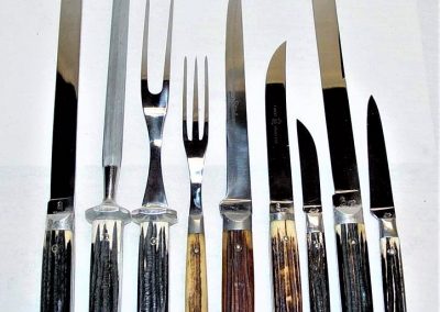 "Kitchen cutlery, nine pieces, Winterbottom bone handles: (left to right) S300 slicer, 10” blade. SS300 sharpening steel, 12 1/2". CF300 carving fork, 10-1/2". SF101 steak fork, 9” H300 steak carver, 6-3/4" blade. U101 steak knife, 4-11/16" Blade. P300SH sheepfoot paring knife, 2-1/4" blade. C300 carver, 9” blade. P300 paring knife, 3” blade."
